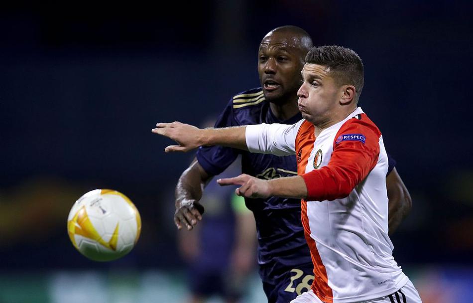 在克罗地亚阴冷秋雨中，身穿蓝色球衣的萨格勒布迪纳摩球员们神情专注，他们与远道而来的荷兰费耶诺德队球员在中场展开激烈绞杀，足球在人群中穿梭，场面胶着。