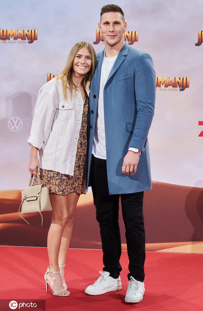 首映礼现场，聚勒带着标志性的憨厚笑容，与一袭长裙的女友面对镜头，两人身后的电影海报增添了几分浪漫气息