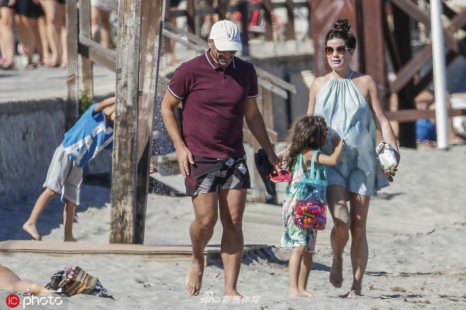 伊比萨岛的度假时光中，马丁内斯手持饮品，神情惬意地享受着西班牙本土的悠闲生活，背景是迷人的海岛风光。