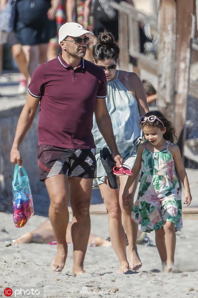 西班牙籍教练马丁内斯身着休闲装，在伊比萨岛的码头边悠然漫步，沐浴着地中海的温暖阳光，神情轻松愉悦。