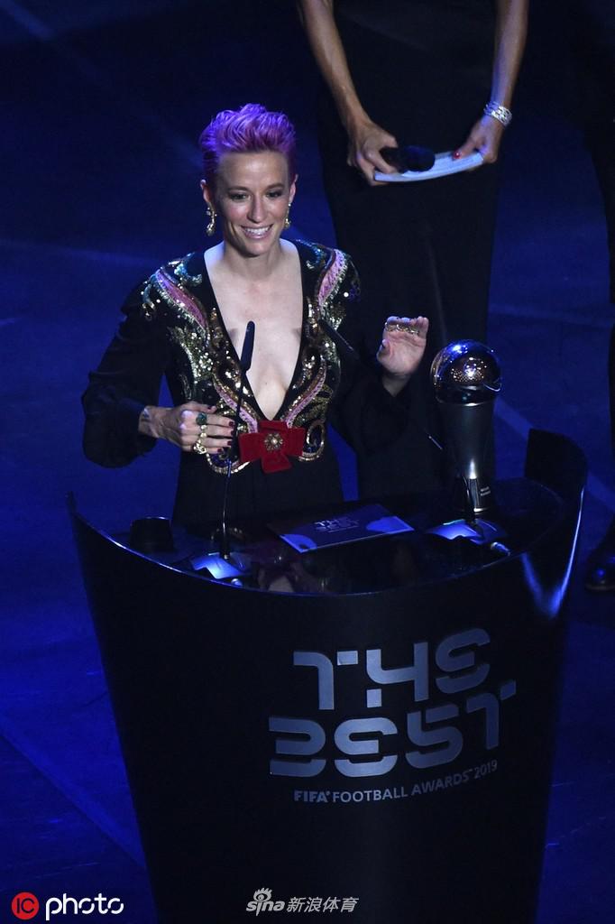 聚光灯完美勾勒出拉皮诺埃的轮廓，她低头注视着手中沉甸甸的世界足球小姐奖杯，嘴角带着一丝感慨与欣慰，仿佛在回味这一年来走过的艰辛与荣耀之路。