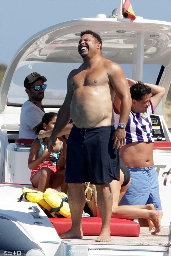 肥罗挺着标志性的大肚腩站在游艇上，对着镜头露出憨厚笑容，粗壮的手臂肌肉在阳光下泛着光，与圆润的腹部形成有趣的对比