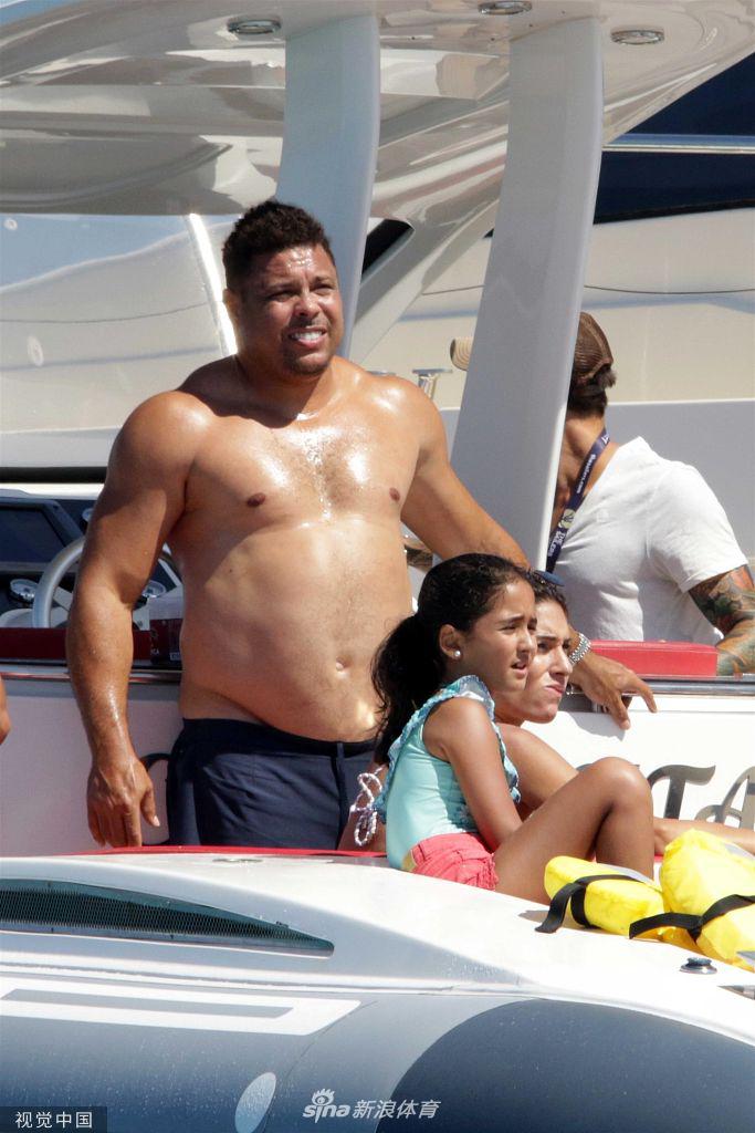 大罗在游艇上侧身与朋友交谈，侧面的角度让他凸起的腹部曲线更为明显，同时结实的手臂和宽阔的肩膀也展现出他上肢的力量感