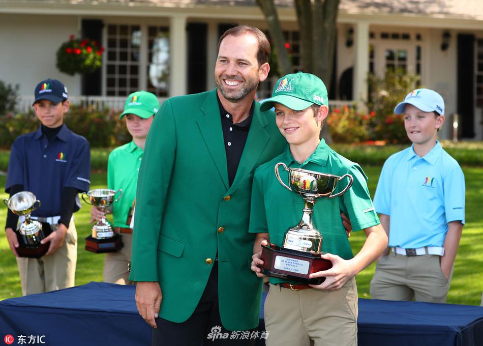 汤姆·沃特森在奥古斯塔三杆洞球场果岭边凝神准备推杆，身后是簇拥的观众与标志性的记分牌。