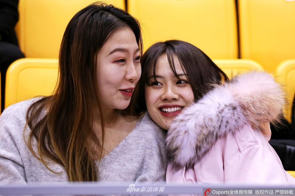 一位面容清秀、扎着马尾的天津女球迷，在现场灯光下专注地看着场内，眼神中充满期待，成为赛场边一道靓丽的风景线。