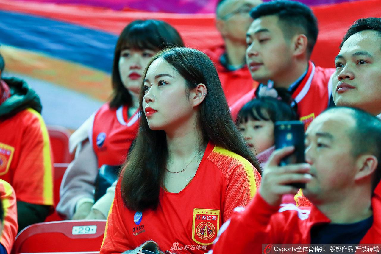 几位身着八一队外套的铁杆球迷并肩而立，他们目光如炬，紧盯着赛场中央，眼神中充满了对胜利的渴望和对主队坚定的支持。