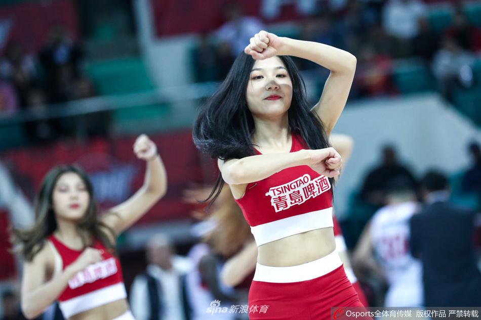 镜头聚焦于一位领舞的篮球宝贝，她拥有精致的五官和迷人的微笑，即使在高强度的舞蹈动作中，依然能保持甜美的表情管理，展现出职业篮球宝贝的专业素养。