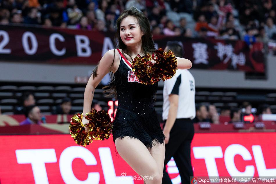 身穿白色队服的啦啦队宝贝马尾辫轻甩,脸上洋溢着灿烂笑容,手持金色花球在赛场中央跃动起舞,为即将开始的比赛注入无限活力