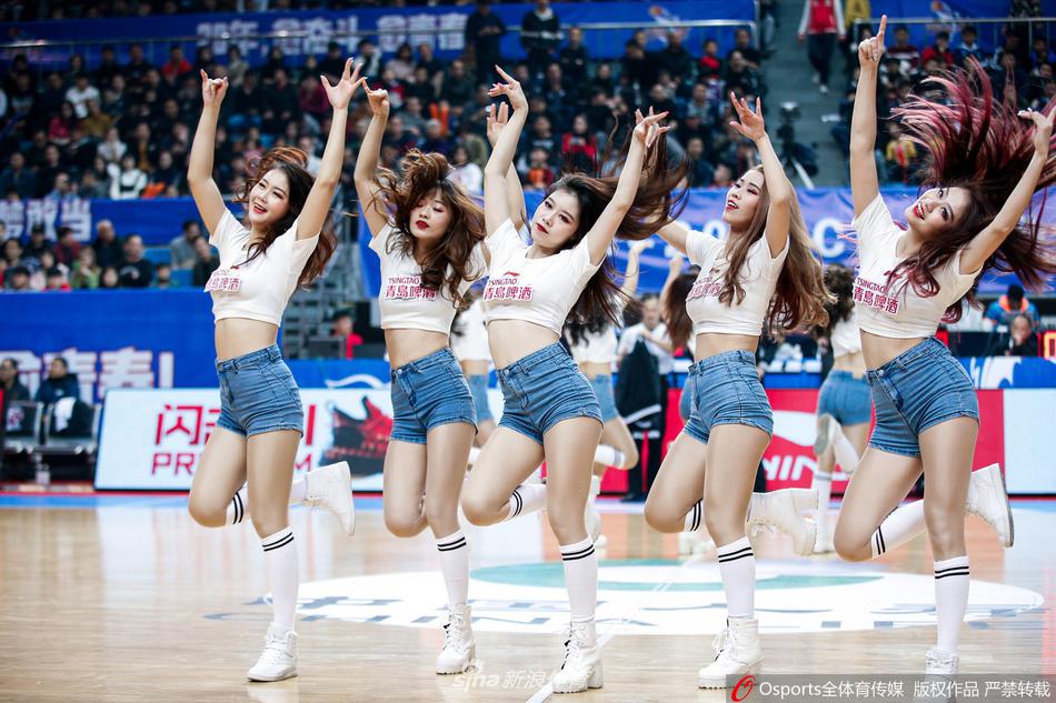 镜头捕捉到一位眼神坚定的篮球宝贝，她在热舞中嘴角上扬，露出自信的微笑，手中花球闪耀的光芒甚至盖过了顶部的聚光灯。