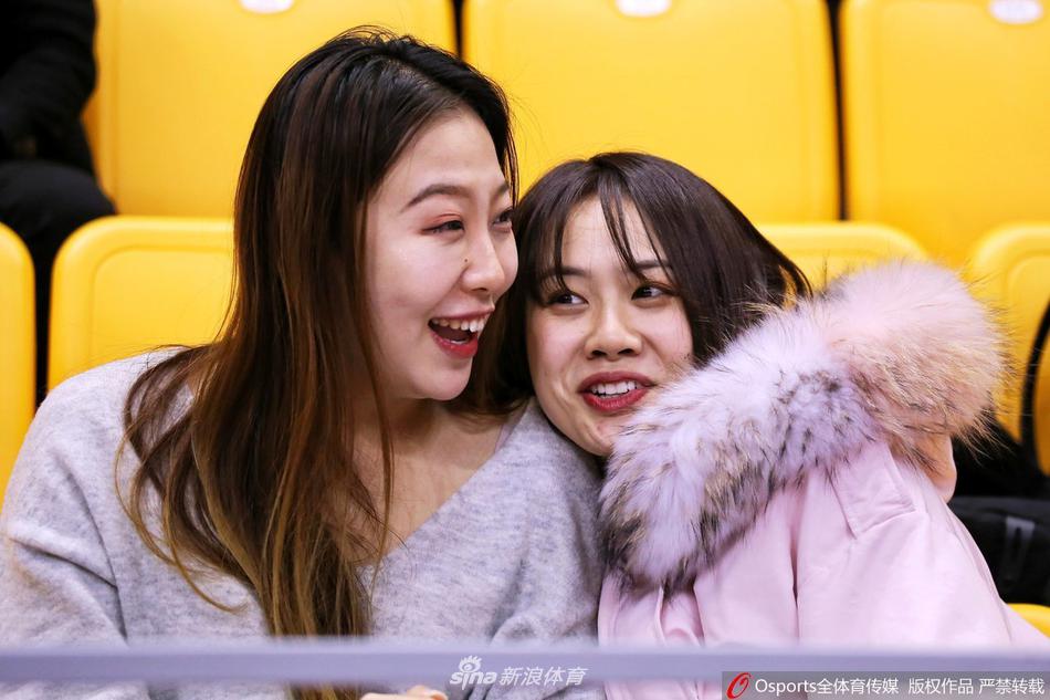 在体育馆明亮的灯光下，这位天津先行者的美女球迷回眸一笑，手中举着助威围巾，展现了青春活力与对主队最真挚的喜爱。