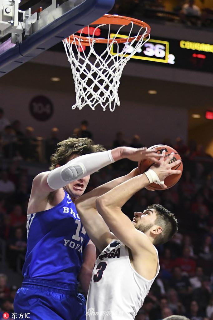 杨百翰大学的核心球员约埃尔·查尔德在巨人丛林中强行上篮。他的身体在空中完全舒展,肌肉线条因为发力而紧绷,面对冈萨加两名防守球员的遮天蔽日,他眼中没有丝毫畏惧,只有对篮筐的无限渴望。这一球,是他全场战斗精神的一个缩影。