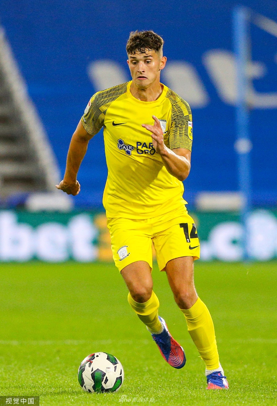 看台上一位身着传统围巾的哈镇老球迷眼神凝重地望着球场，复杂的情绪写在脸上