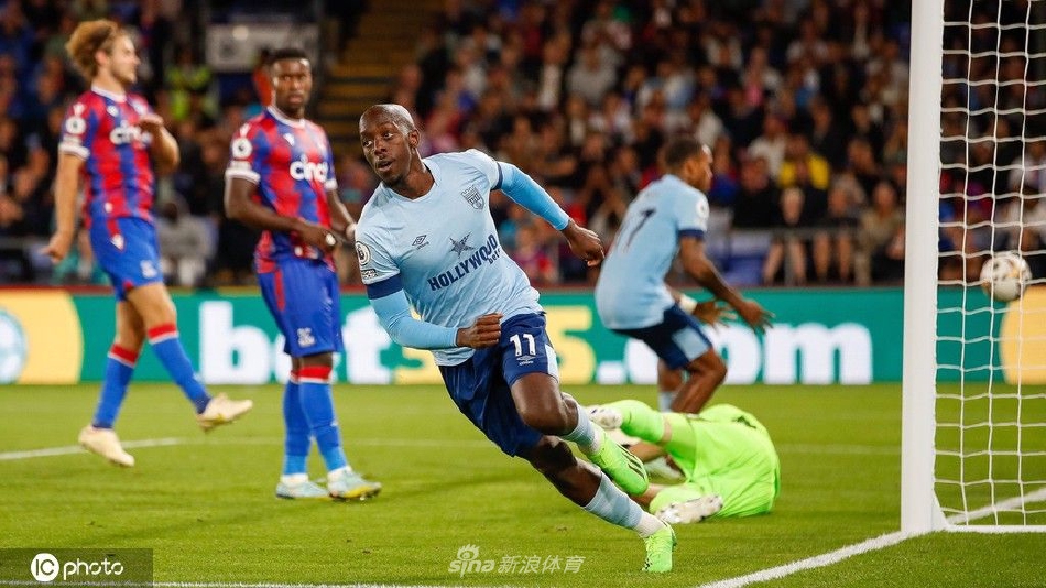 水晶宫球员埃泽破门后张开双臂狂奔庆祝，身后是激动万分扑上来的队友，背景里看台上主场球迷陷入疯狂的欢呼浪潮。