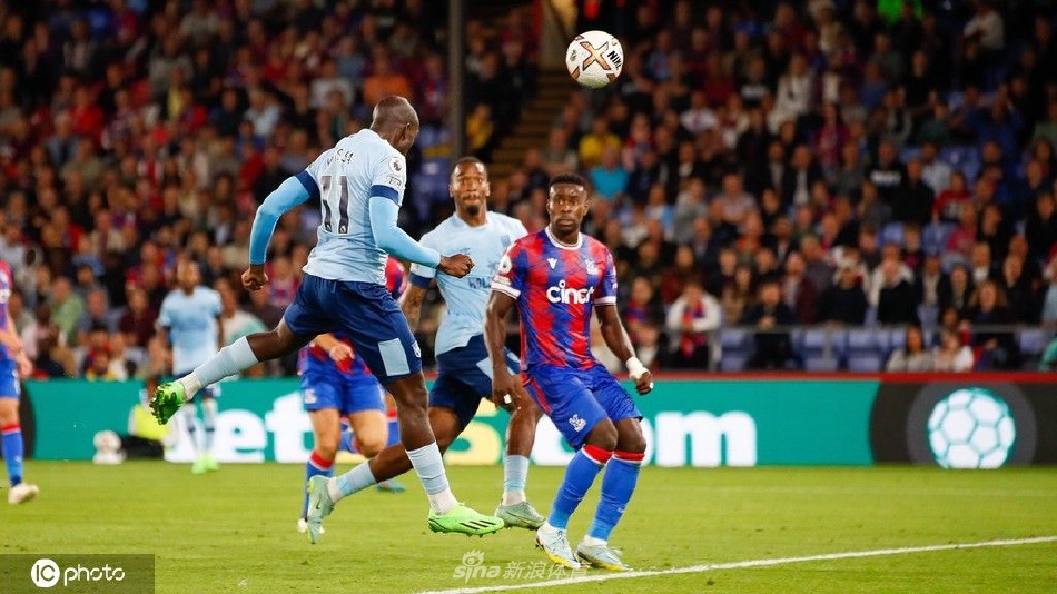 水晶宫前锋扎哈带球突破，面对两名布伦特福德防守球员的包夹，他压低重心，眼神坚定，准备从人缝中寻觅突破路线。