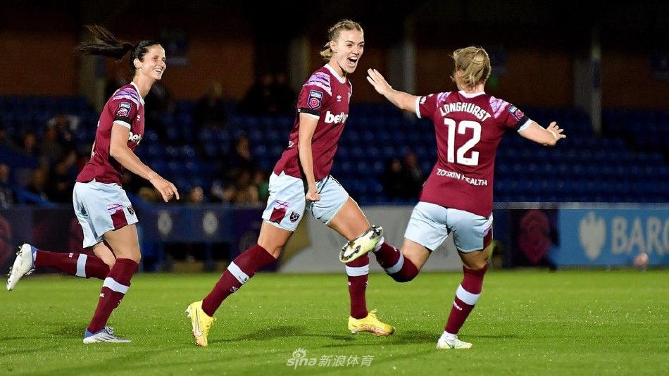 比赛结束后，切尔西女足队员们相互拥抱庆祝胜利，脸上写满喜悦，背景是正在离场的观众看台。