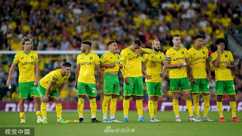 点球大战中门将飞身扑救，身体完全舒展，眼神锐利地锁定飞行中的足球