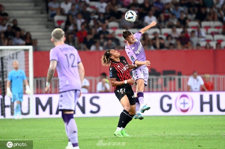 尼斯队球员在失球后神情凝重，围在一起相互鼓劲，背景中庆祝的摩纳哥球员身影模糊，凸显了比赛结果的残酷对比