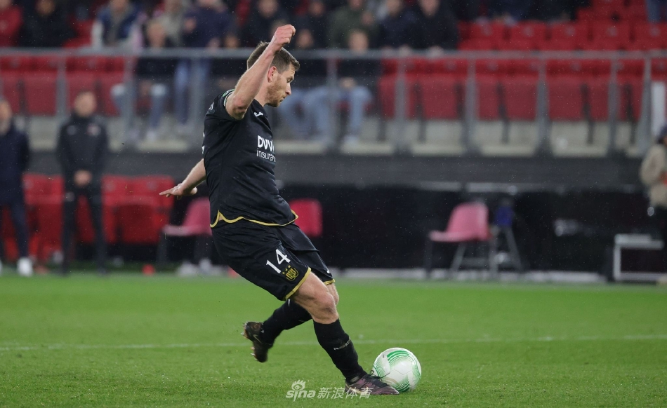 阿尔克马尔门将马修·瑞安在点球大战中聚精会神，张开双臂准备扑救，背景是紧张注视的队友。