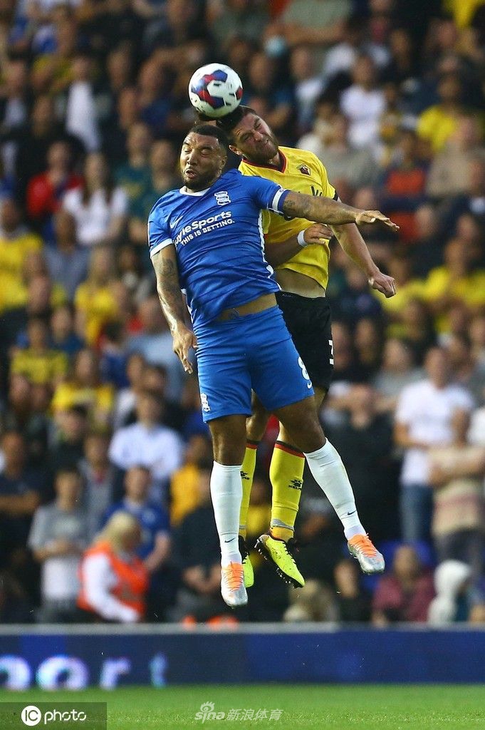 沃特福德主教练罗布爱德华兹站在场边，神情专注地凝视着雨中激烈的赛场。