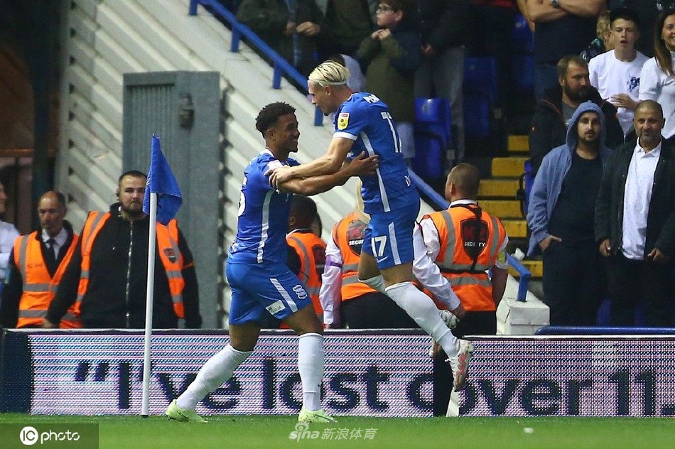 伯明翰年轻球员乔治霍尔张开双臂在雨中庆祝自己职业生涯的首粒进球，周围是兴奋的队友。