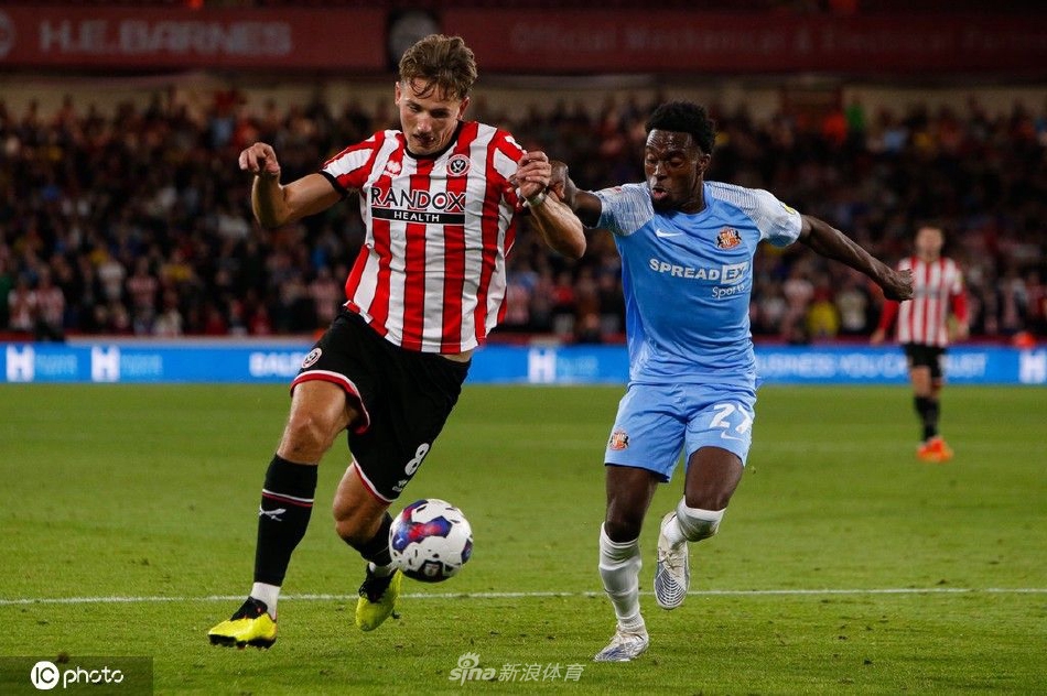 比赛激烈进行中，双方球员在中场区域贴身拼抢，互不相让，展现了英冠联赛高强度的身体对抗特点。