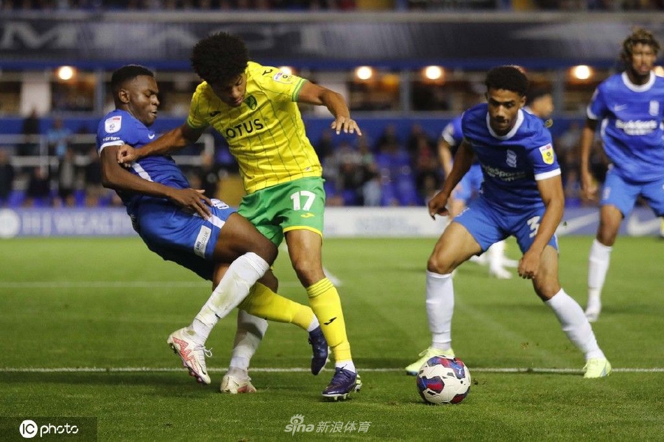 双方中场球员激烈拼抢，鞋钉带起的草屑飞溅，身体对抗在电光石火间展现力量与技术的角逐。