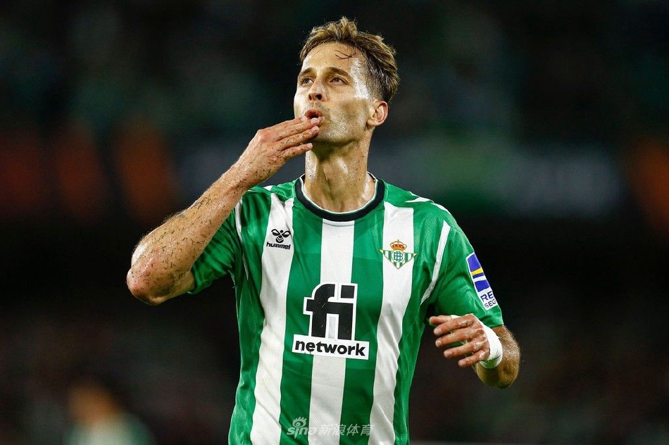 贝蒂斯球员打入世界波后张开双臂奔向角旗区，与疯狂涌来的队友激情相拥