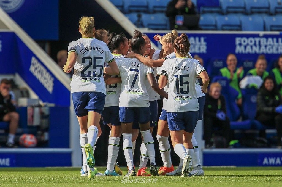 双方球员在中场高空争顶，阳光勾勒出她们奋力起跳的矫健身影，对胜利的渴望展露无遗。