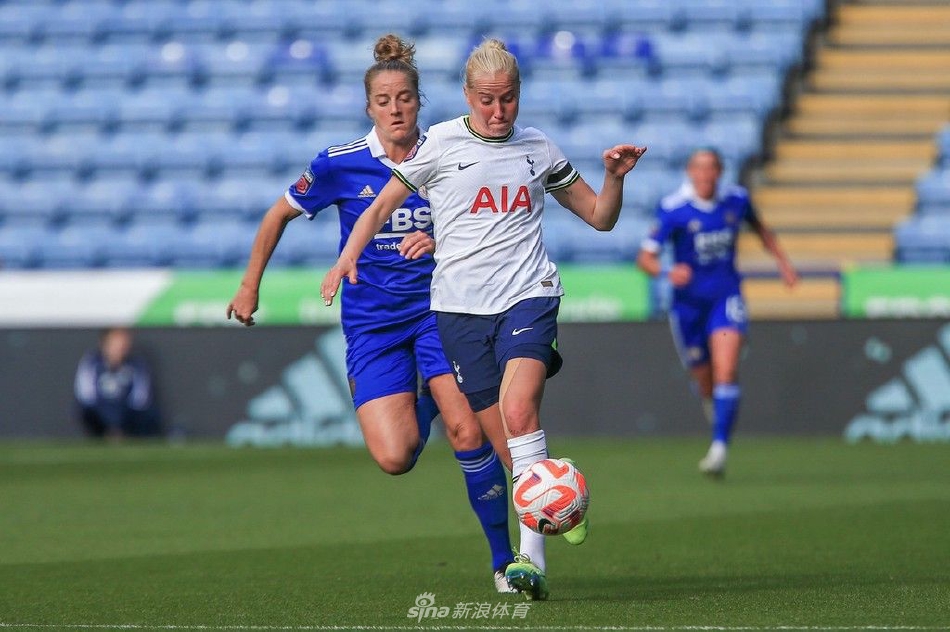 热刺队球员进球后张开双臂奔向角旗区庆祝，身后是欢呼的队友和略显沮丧的莱斯特城防守球员。