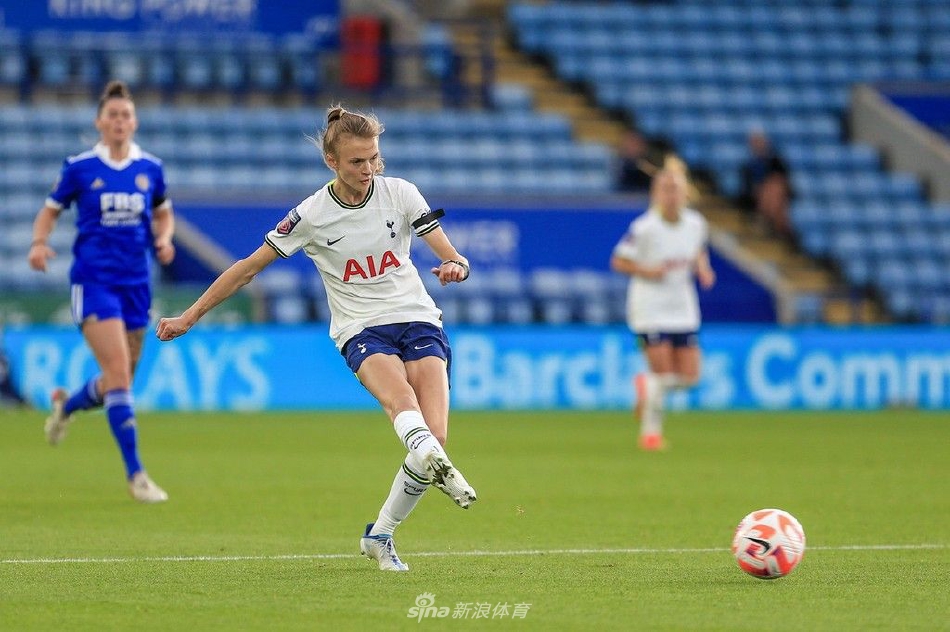 比赛激烈进行中，一名球员失去平衡倒地，另一名球员伸出手表示关心与友好，体现了竞技体育中的尊重。