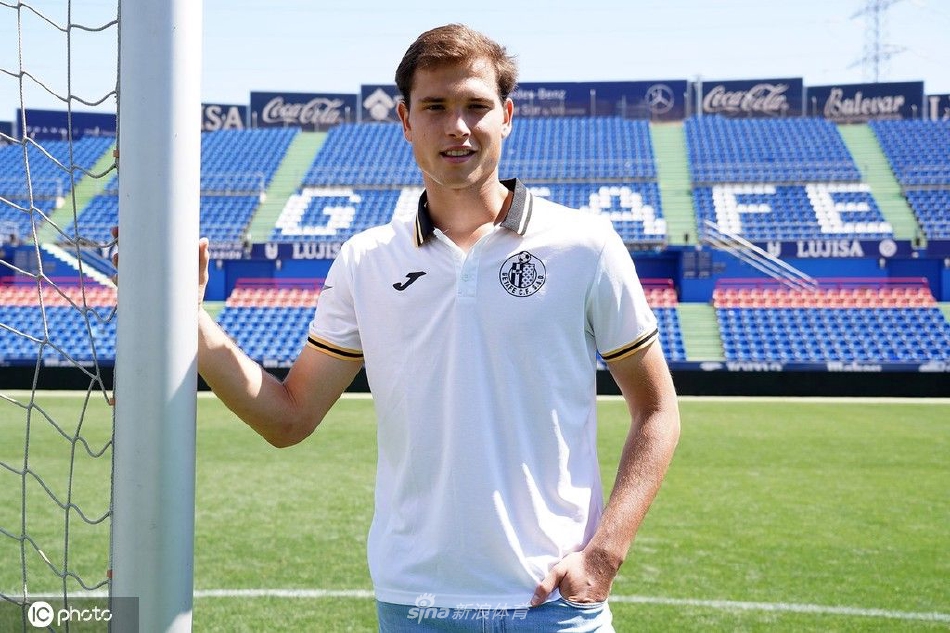 新闻发布会上，拉塔萨侧耳倾听记者提问，神情专注，展现出职业球员的认真态度