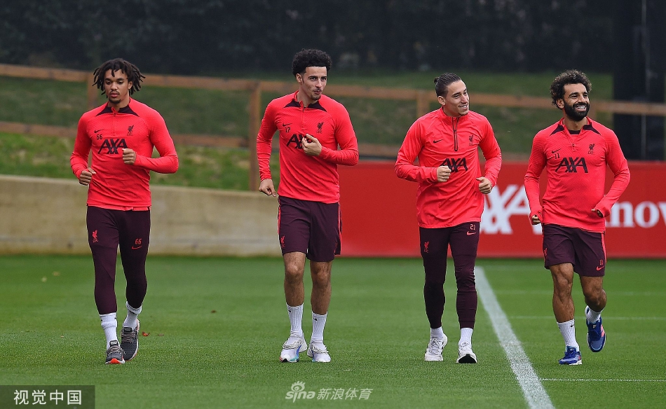 两名利物浦球员在对抗中同时起跳争顶头球，肌肉紧绷，展现出极强的身体对抗与竞争意识