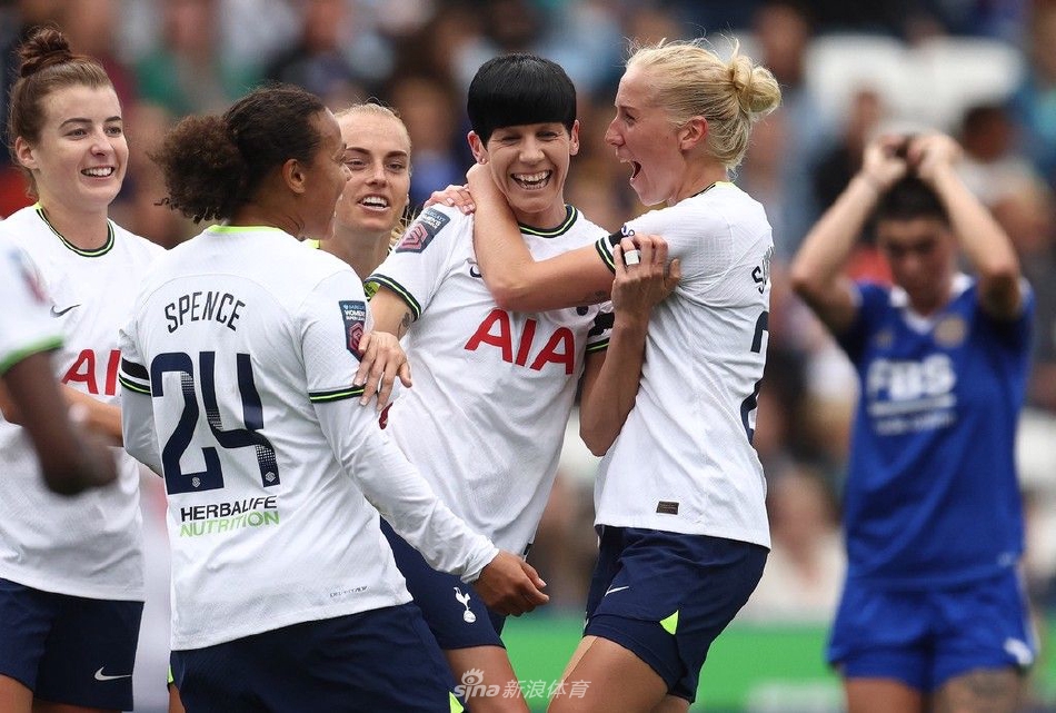 热刺女足前锋在莱斯特城后卫紧逼下灵巧转身，即将起脚射门，球场边观众席座无虚席，气氛热烈。