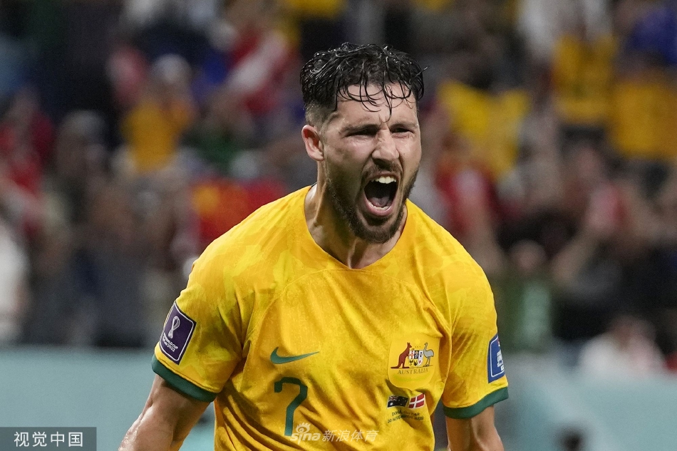 马修·莱基进球后张开双臂，如雄鹰展翅般在全场飞奔庆祝，脸上绽放着狂喜与释放的笑容，身后是目瞪口呆的丹麦后卫和背景里一片欢腾的澳大利亚球迷看台。