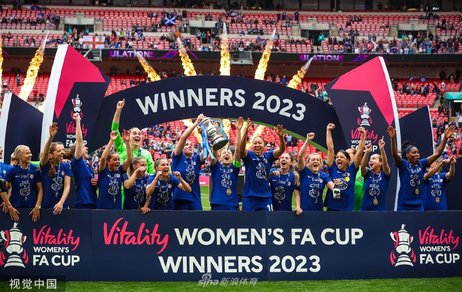 切尔西队长米莉·布莱特与老将马格达莱娜·埃里克森共同高举女子足总杯冠军奖杯，身后是漫天飞舞的蓝白色彩带与欢庆的队友。