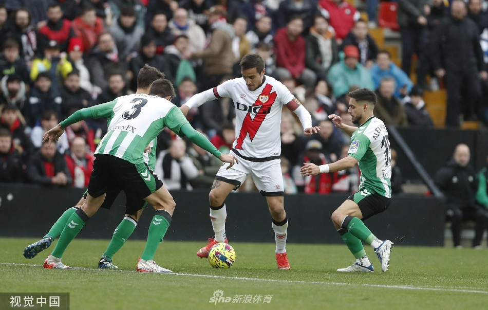 巴列卡诺球员带球突破贝蒂斯防守，双方球员在激烈对抗中身体交错