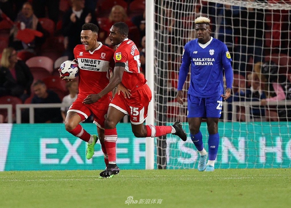 米德尔斯堡球员在终场哨响后神情沮丧，双手叉腰低头不语，而远处卡迪夫城球员正在欢庆胜利。