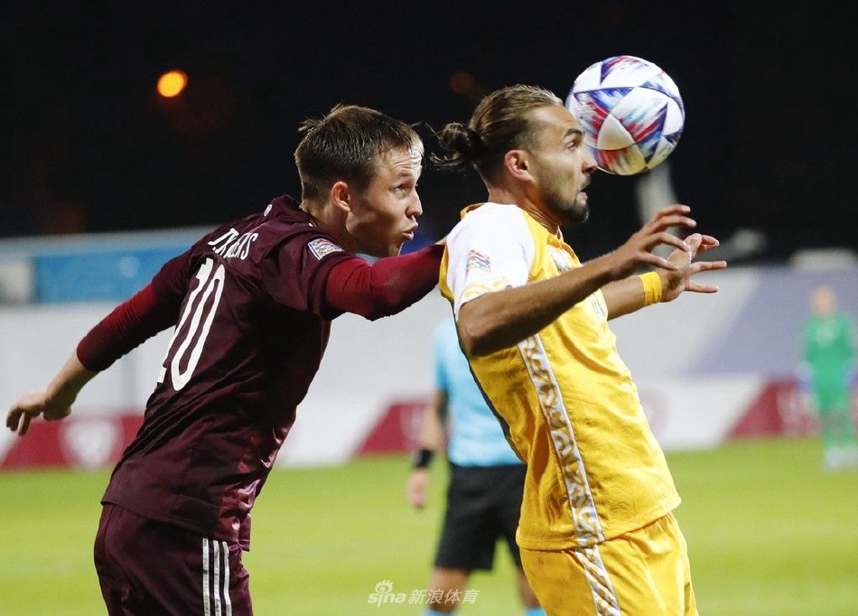 拉脱维亚前锋在对方禁区前沿带球突破，眼神坚定，奋力摆脱防守球员的纠缠。