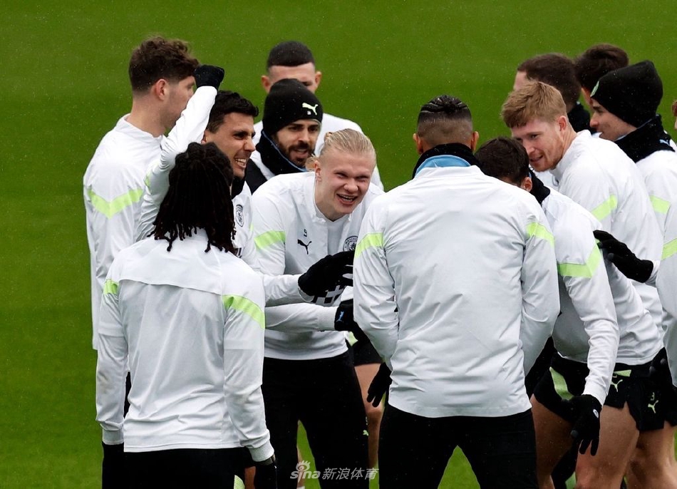 主帅瓜迪奥拉神情专注，手持战术板，在训练场边向核心球员德布劳内细致讲解跑位路线，阳光将两人的身影拉长，仿佛一幅构思精密战术的画卷。