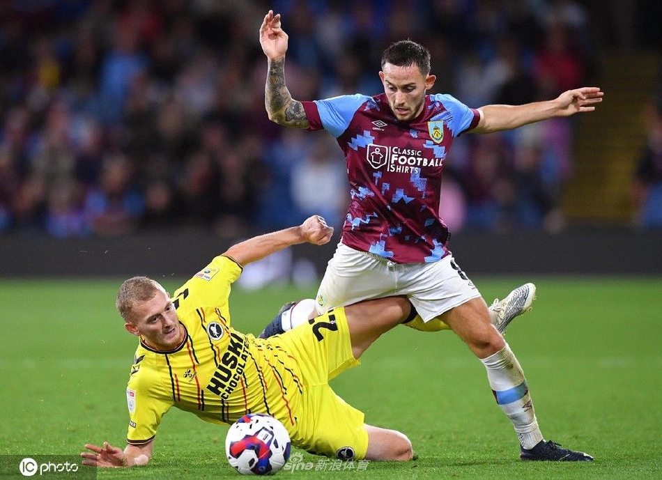 伯恩利球员围成一圈相互鼓舞，汗水在球场灯光下闪烁，展现全队团结一心的战斗精神