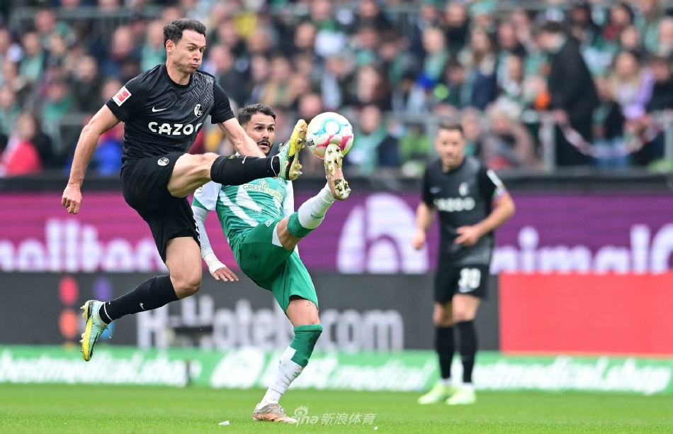 弗赖堡队员在完成逆转后紧紧相拥庆祝，场边的主教练振臂高呼，激动之情溢于言表。