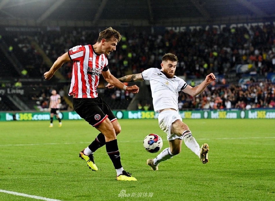 斯旺西队中场核心陷入谢联两人包夹，他奋力护住皮球，身体对抗的张力透过画面扑面而来。