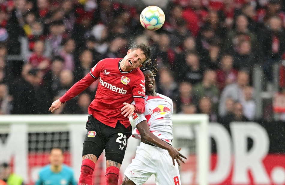 勒沃库森球员庆祝胜利：进球功臣阿米里被队友们团团围住，全队洋溢着击败强敌后的狂喜与团结