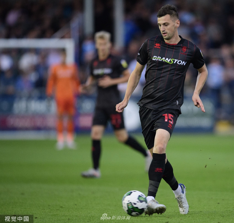 巴罗队球员在进球后疯狂拥抱庆祝，背景中可以看到看台上主场球迷挥舞围巾、激情呐喊的震撼场景。