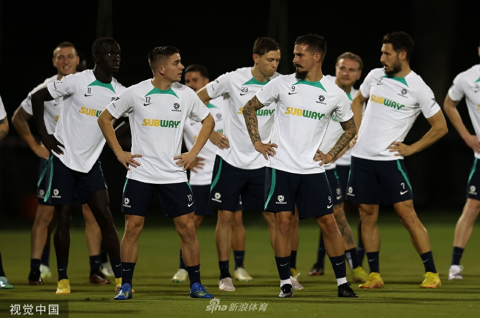 夕阳下的训练场，澳大利亚队球员们围成一圈聆听教练的战术部署，身影被拉长，画面充满专注与奋进的仪式感。