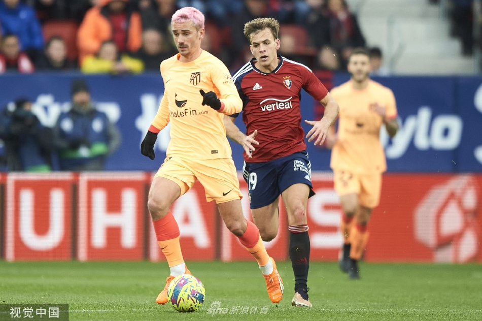 奥萨苏纳主帅神情专注地凝视赛场，手中的战术板承载着扭转战局的思考与期望。