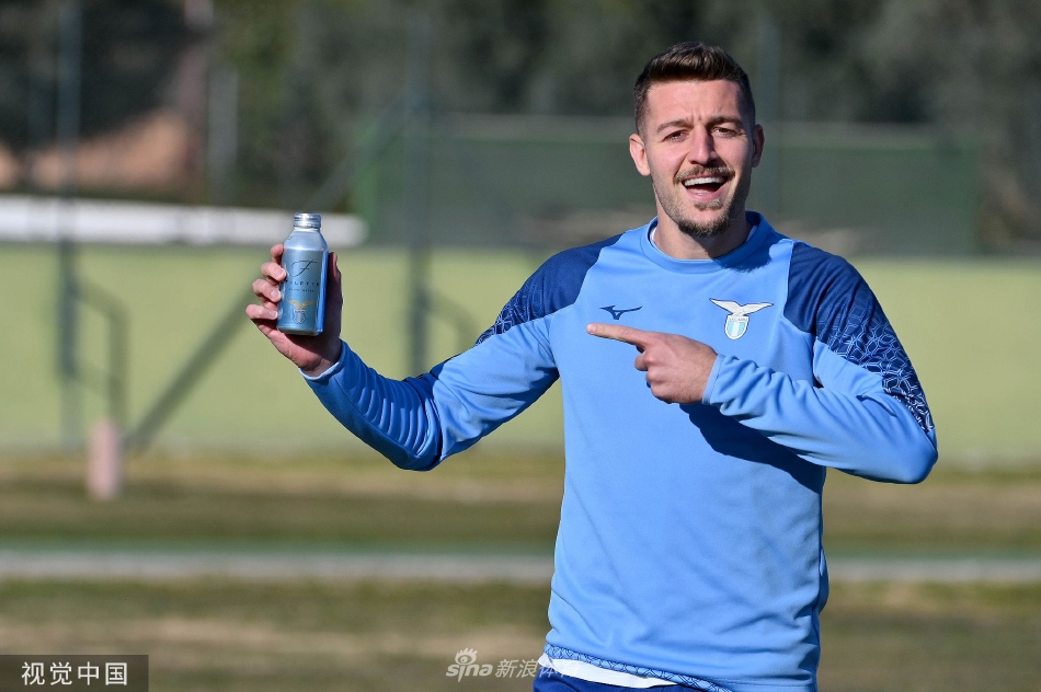 主教练萨里神情专注地站在训练场边，手持战术板，正在向围拢的拉齐奥球员们讲解关键的对阵策略。