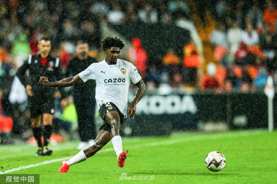 乌戈·吉利亚蒙点球破门后紧握双拳怒吼，脸上写满释放与激情，背景是失落的贝蒂斯门将和球网中的皮球