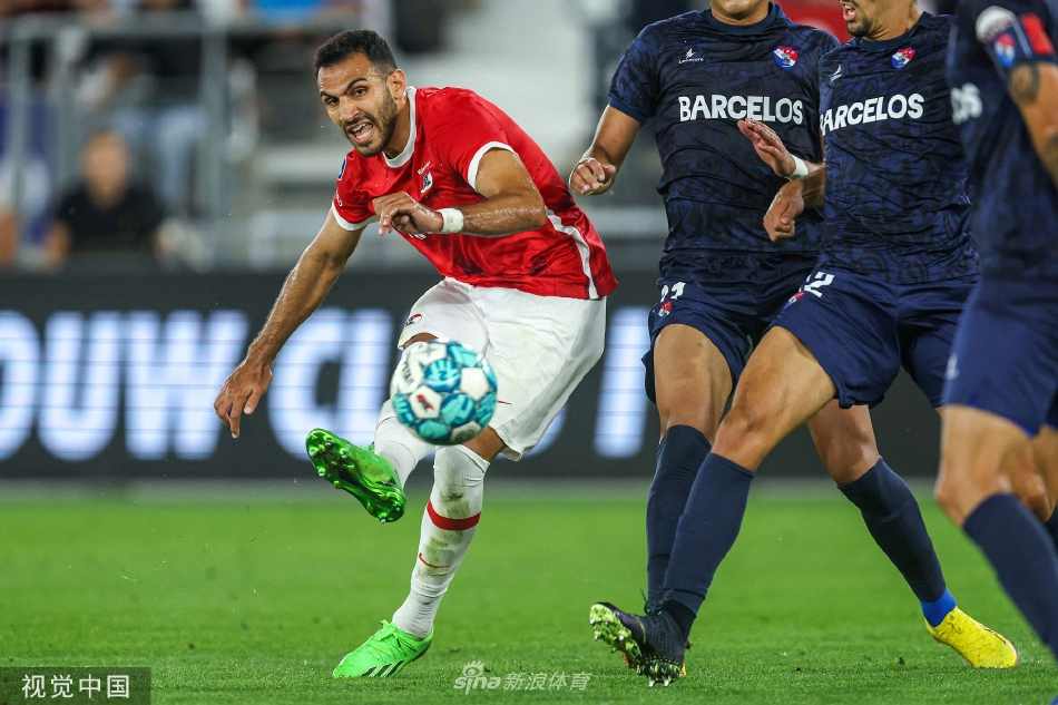 阿尔克马尔门将飞身扑救后紧抱足球，神情专注地指挥队友布置防线