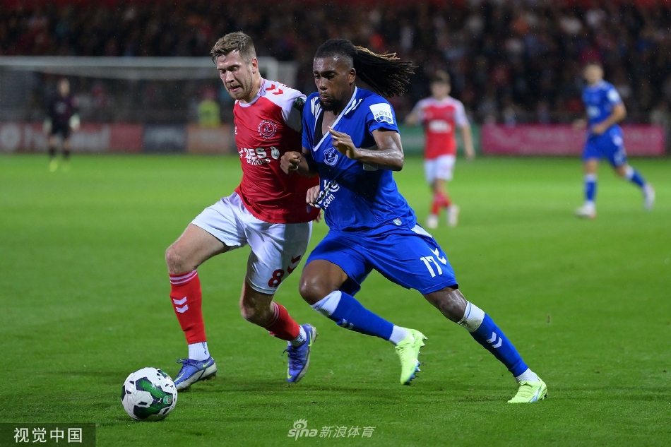 比赛结束后，一名汗流浃背的弗利特伍德球员低头走下场，他的球衣沾满草渍，身影在巨大的球场灯光下显得落寞却又无比坚强。